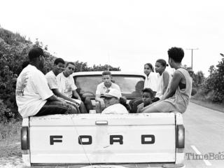 Teenagers riding in back of a truck
